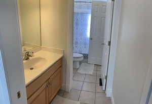 Bathroom with tile patterned flooring, vanity, and toilet