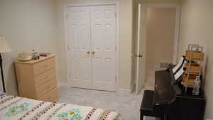 Bedroom with light colored carpet and a closet