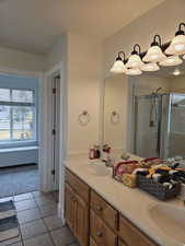 Bathroom featuring tile patterned floors, vanity, and walk in shower