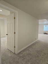 Corridor with carpet flooring and a textured ceiling