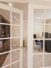 Interior space with carpet, ornamental molding, and french doors