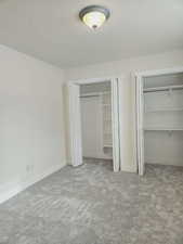 Unfurnished bedroom with light carpet and a textured ceiling