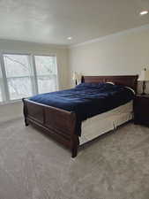 Bedroom featuring multiple windows, carpet floors, and ornamental molding