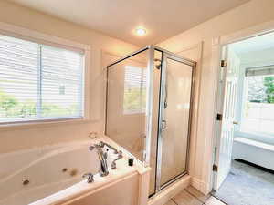 Bathroom featuring tile patterned flooring, plenty of natural light, and independent shower and bath