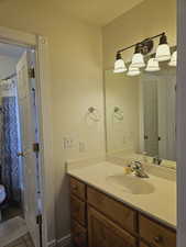 Bathroom featuring a shower with curtain, vanity, and tile patterned floors