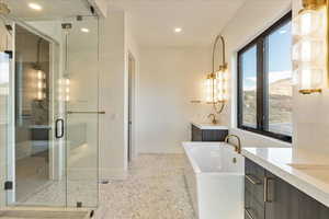 Bathroom featuring tile patterned floors, vanity, and shower with separate bathtub