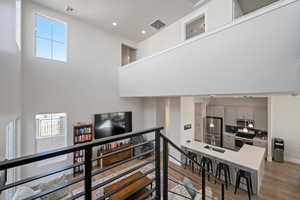 Stairs with hardwood / wood-style flooring, a towering ceiling, and sink