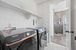 Laundry area featuring washer and dryer and light tile patterned floors