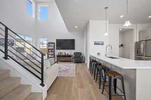 Interior space with sink, a high ceiling, and light hardwood / wood-style flooring