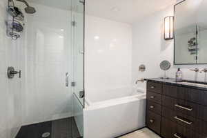 Bathroom with vanity, tile walls, and walk in shower