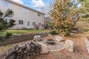 Back of property with a yard and a fire pit