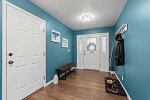 Entrance foyer featuring dark wood-type flooring and a textured ceiling