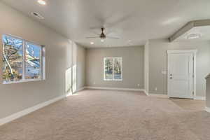 Carpeted living room with ceiling fan