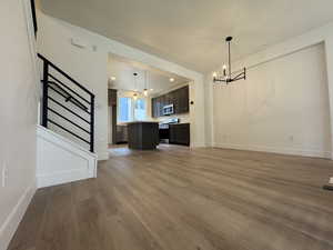 Unfurnished living room with hardwood / wood-style floors and a chandelier