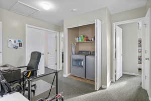Office area featuring washer and dryer and dark colored carpet