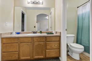 Bathroom featuring tile patterned flooring, vanity, toilet, and walk in shower