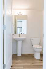 Bathroom featuring hardwood / wood-style floors and toilet