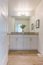 Bathroom with vanity, a textured ceiling, and hardwood / wood-style flooring