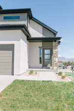 View of front of home featuring a mountain view, a garage, and a front yard