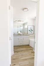 Bathroom with hardwood / wood-style flooring, vanity, and a textured ceiling