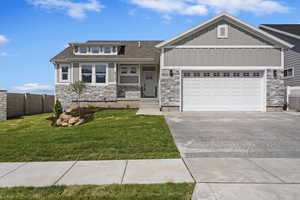 View of front of house with a garage and a front lawn