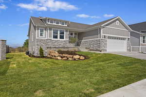 View of front facade featuring central AC unit, a garage, and a front lawn