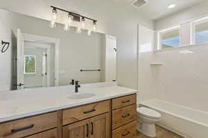 Full bathroom with hardwood / wood-style floors, vanity, toilet, and shower / tub combination