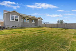 Rear view of house with a lawn and a mountain view