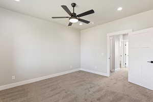 Carpeted spare room featuring ceiling fan