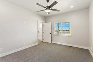 Carpeted empty room with ceiling fan