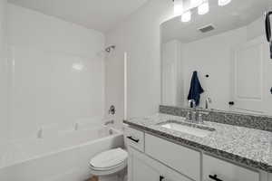 Full bathroom featuring shower / washtub combination, vanity, and toilet