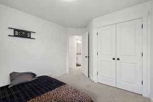 Bedroom with a closet and light colored carpet