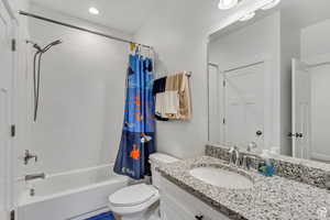 Full bathroom with shower / bath combination with curtain, toilet, and vanity