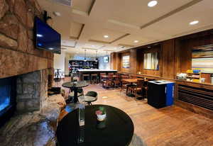 Interior space featuring beam ceiling, wooden walls, coffered ceiling, and light wood-type flooring