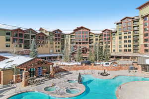 View of pool with a patio and a hot tub