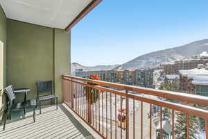 Snow covered back of property with a mountain view