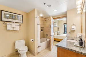 Full bathroom featuring tile patterned floors, vanity, toilet, and shower / bathtub combination with curtain