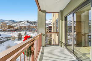 Snow covered back of property with a mountain view