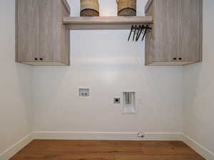 Laundry room with custom cabinetry, gas and electric dryer connections and custom tile work