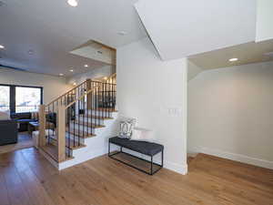 Staircase featuring hardwood floors