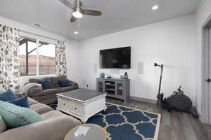 Living room with ceiling fan and dark hardwood / wood-style flooring