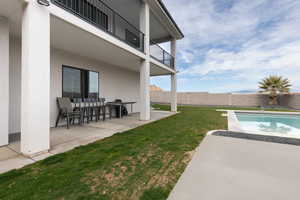 View of yard featuring a patio area, a fenced in pool, an outdoor bar, and a balcony