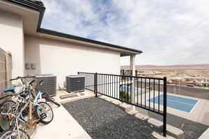 View of patio / terrace featuring central AC and tennis court