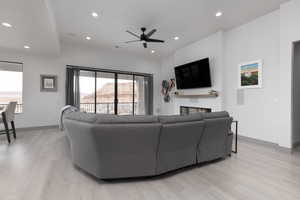 Living room with light hardwood / wood-style floors and ceiling fan