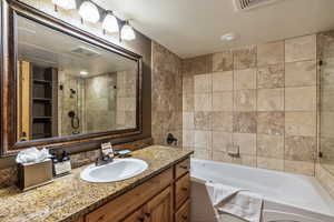 Bathroom with vanity, a textured ceiling, and plus walk in shower