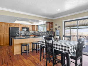 Dining space featuring dark hardwood / wood-style flooring, ornamental molding, and sink