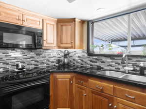 Kitchen featuring tasteful backsplash, sink, and black appliances