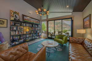 Living room with wooden ceiling, lofted ceiling, and an inviting chandelier