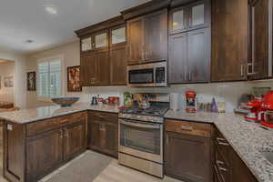 Kitchen with appliances with stainless steel finishes and light stone counters