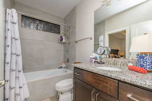 Full bathroom with vanity, toilet, and shower / bathtub combination with curtain